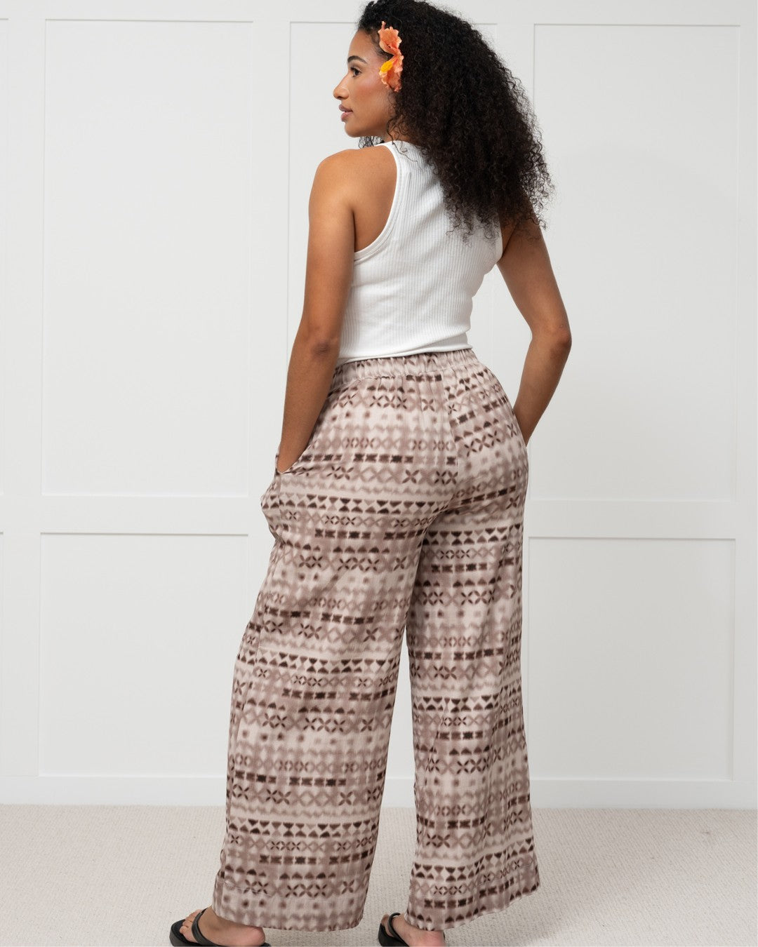 Womens against white wall in pacific motif island fashion pants