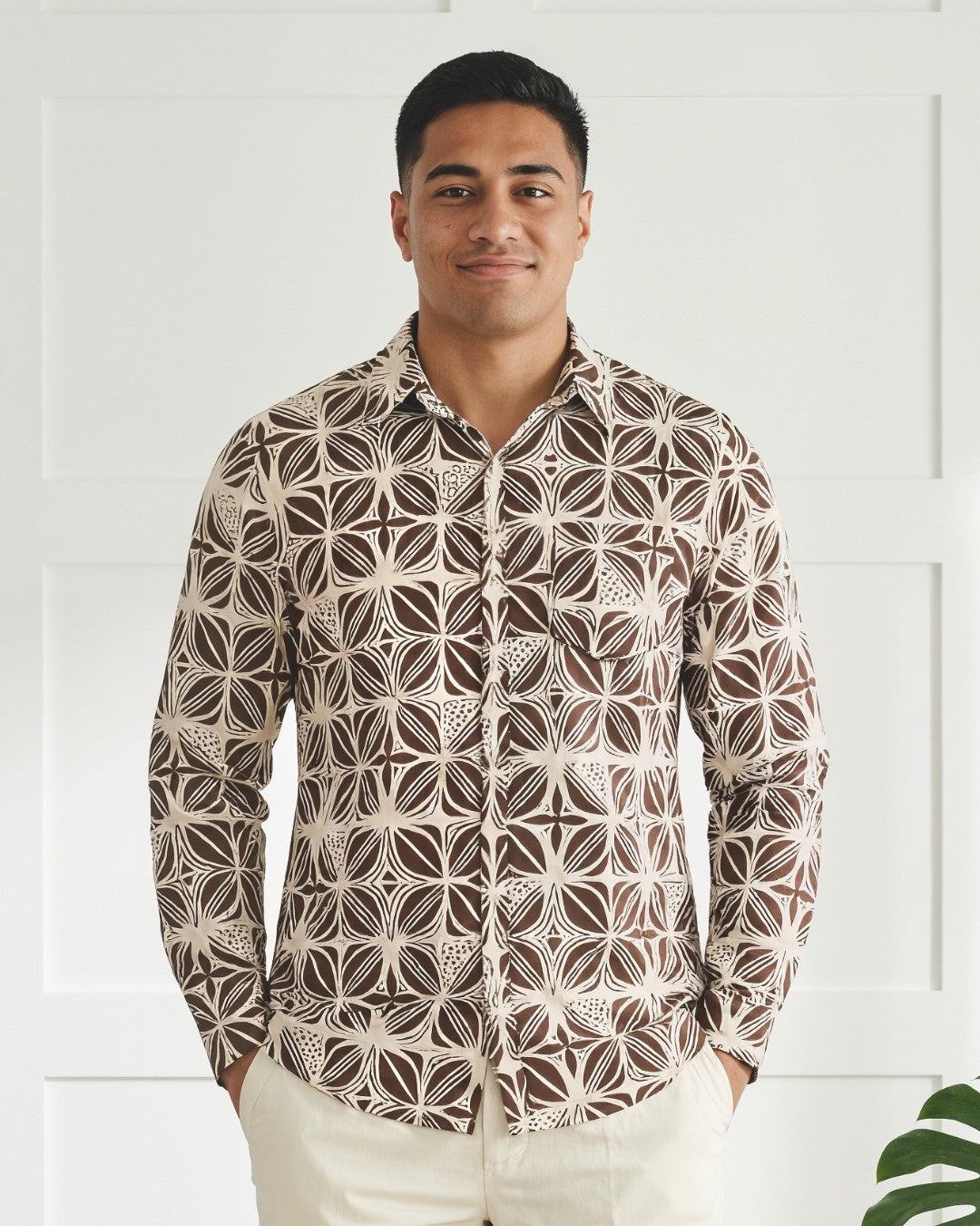 Man wearing a patterned shirt with a white background