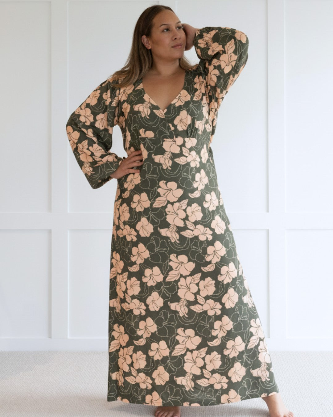 Woman wearing a floral island dress with a plain background