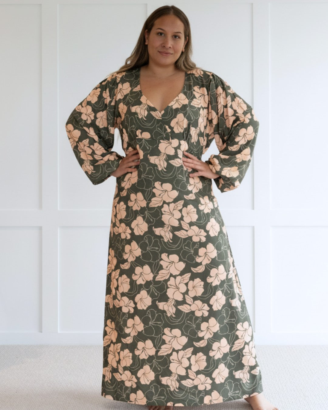 Woman wearing a floral island dress with a plain background