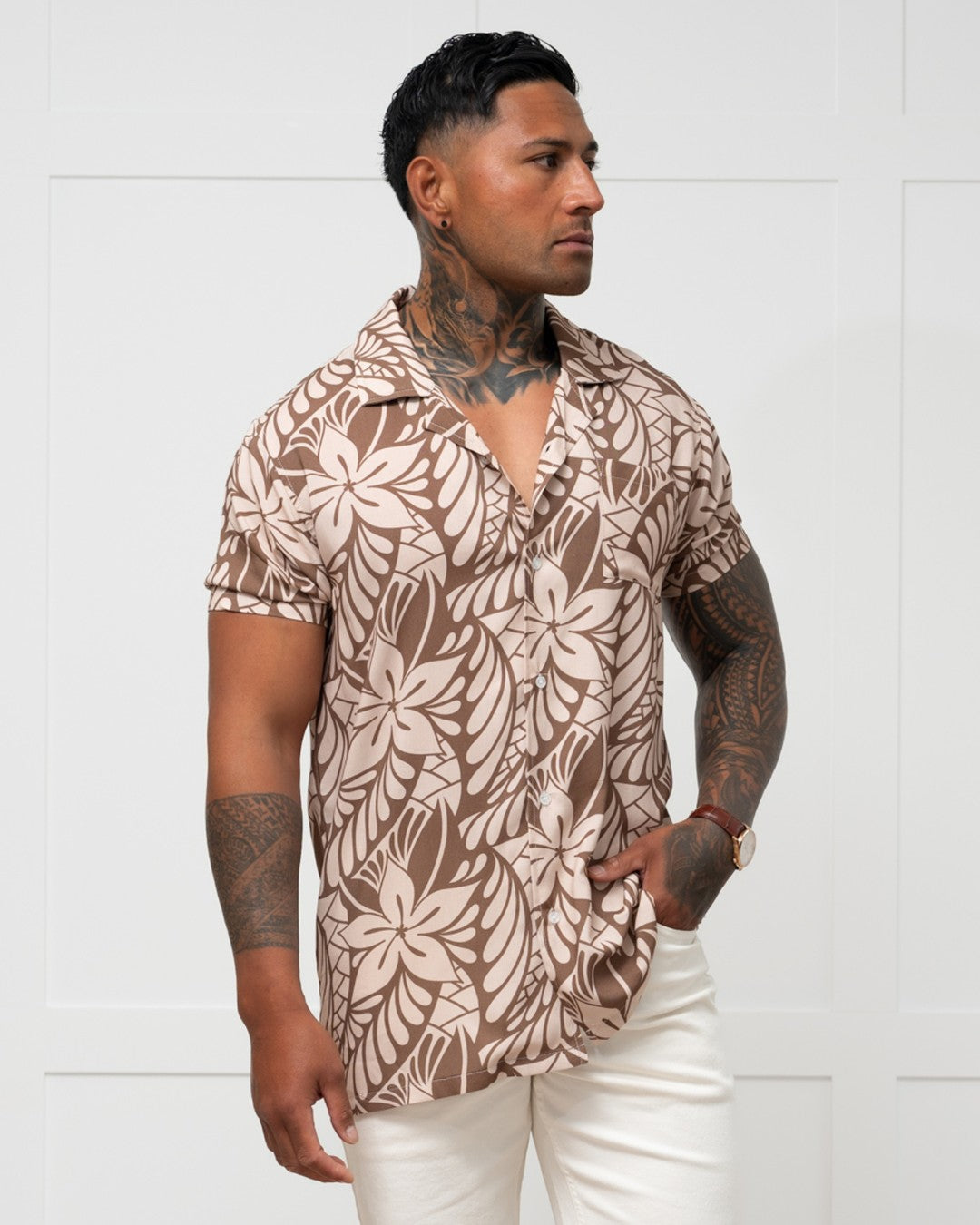 Man wearing a brown floral patterned shirt against a white background