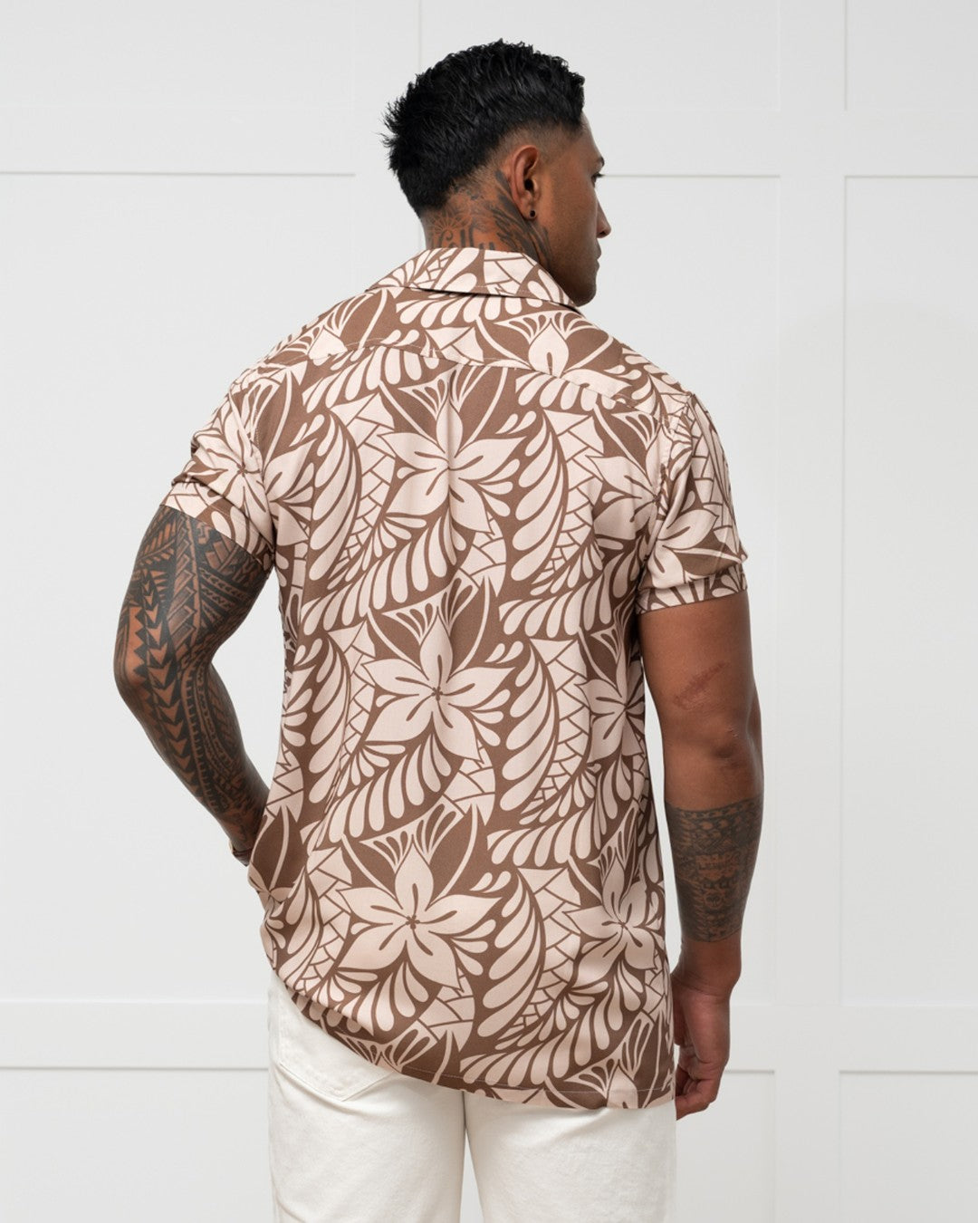Man wearing a brown floral patterned shirt against a white background