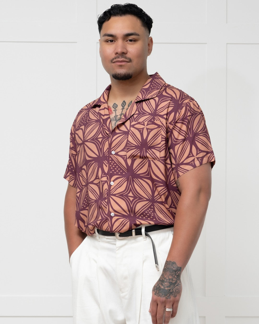 Man wearing a patterned island shirt with a white background
