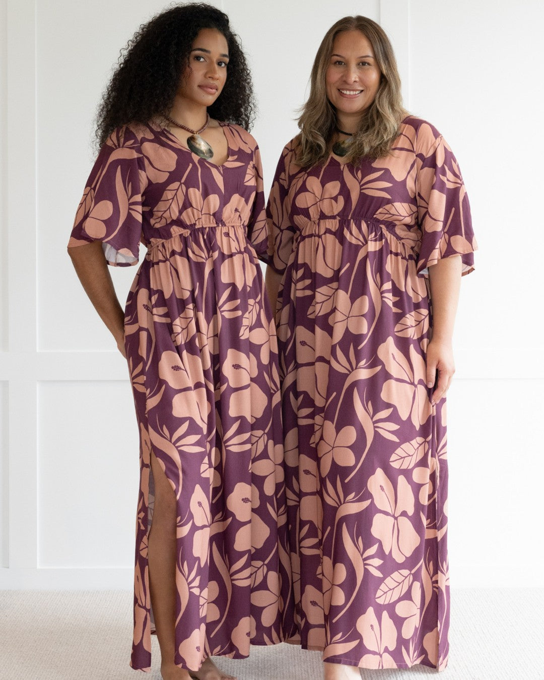 Woman wearing a purple floral island dress with a white background