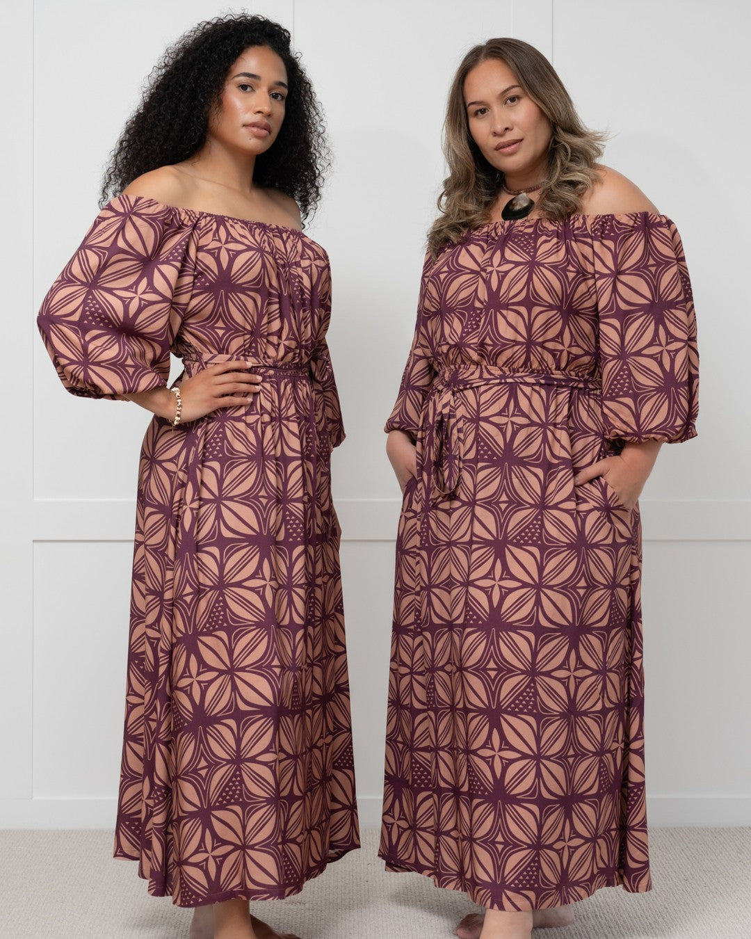 Woman wearing a patterned island dress against a white wall